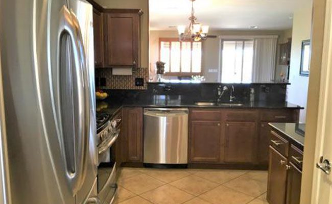 A kitchen with stainless steel appliances and wooden cabinets.