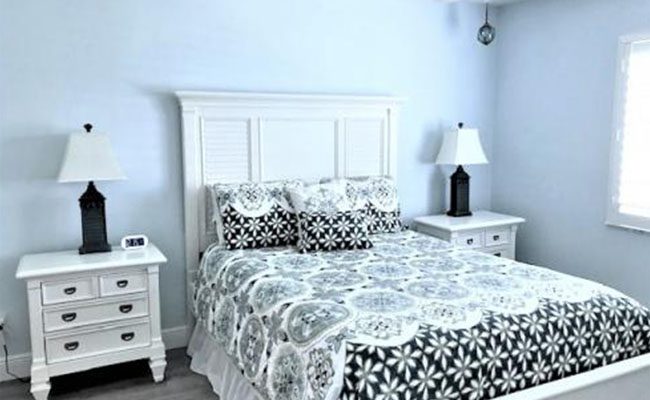 A bedroom with two nightstands and a bed.