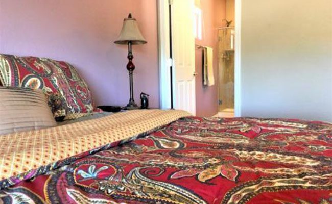 A bedroom with a bed and lamp in it