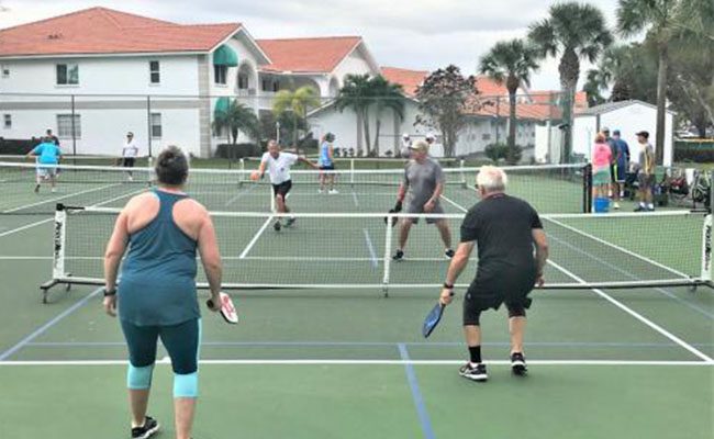 A group of people playing tennis on the court