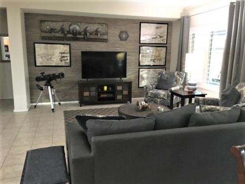 A living room with a couch, chair and television.