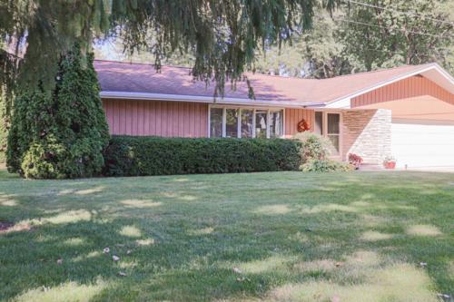 A pink house with green grass and trees